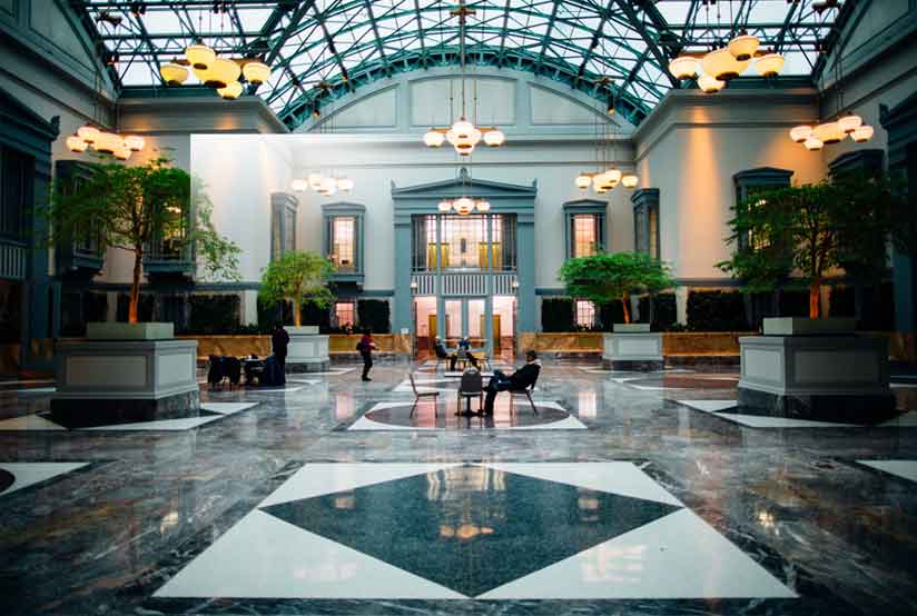 A lobby with people sitting on the floor.